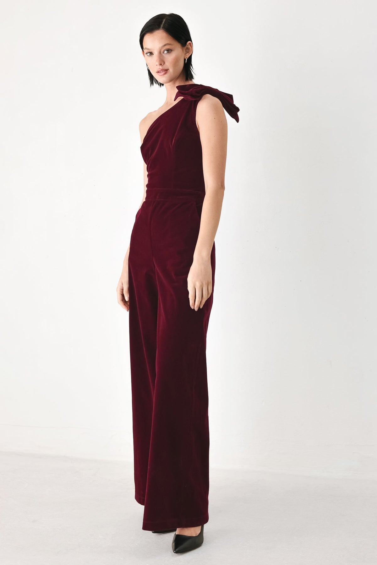 BERRY AFTER DARK VELVET BOW ONE-SHOULDER JUMPSUIT